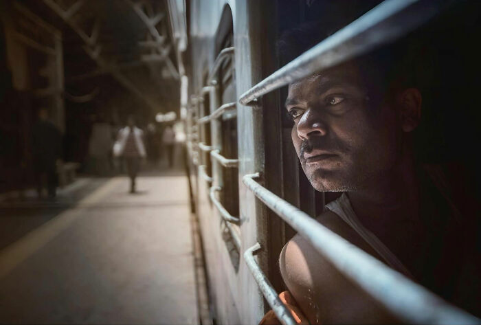 Man looking out from a train window, captured in a candid moment of everyday life in Istanbul.