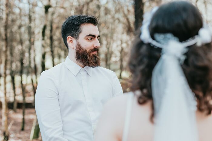 Bearded man in white shirt looking at woman with veil outdoors, illustrating signs a relationship isn’t going to last.