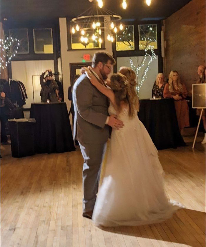 Couple dancing at a wedding reception with guests watching, highlighting Abby and Brittany conjoined twins with a baby question.
