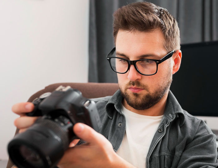 Photographer reviewing camera settings during school project crash at wedding after bride&rsquo;s sister confrontation in university.