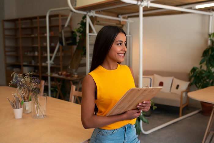 Young woman smiling and holding a clipboard, representing people whose glory days were in high school and life after.
