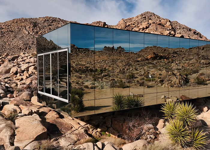 Mirrored invisible house in a rocky desert landscape, a famous Airbnb destination attracting influencer selfies.