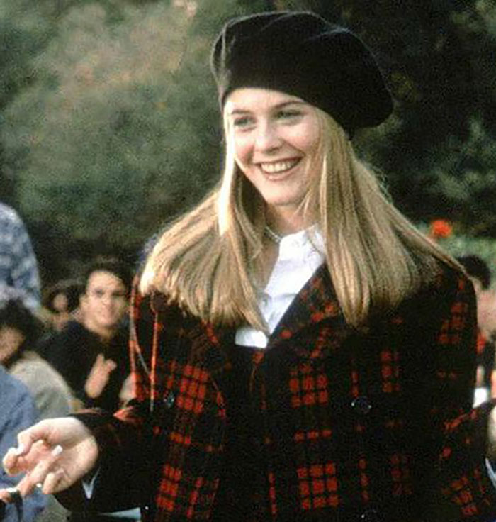 Alicia Silverstone smiling outdoors wearing a black beret and red plaid jacket, showcasing youthful looks and radiant appearance. Alicia Silverstone smiling outdoors wearing a black beret and red plaid jacket, showcasing youthful looks and radiant appearance.