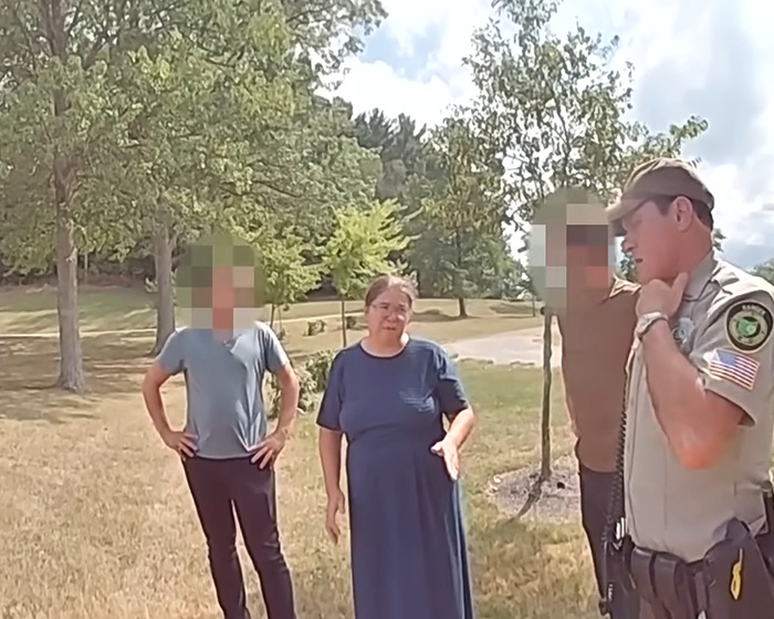Amish mom speaking with officers outdoors in a park setting in a chilling confession after drowning incident.
