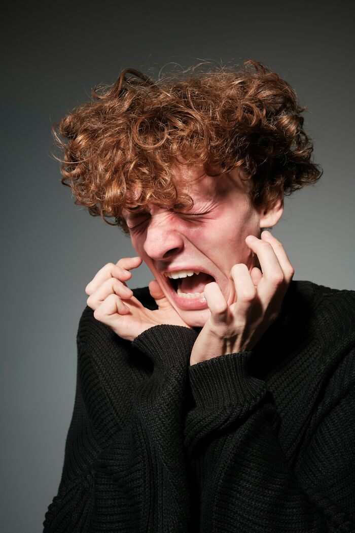 Young man with curly hair showing intense fear and anxiety, illustrating moments when home alone turned horrifying.