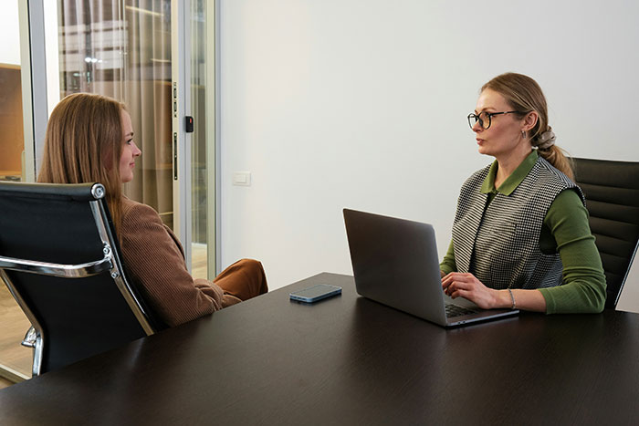Woman in an office meeting with manager discussing fitness concerns and suggesting time off to lose weight.