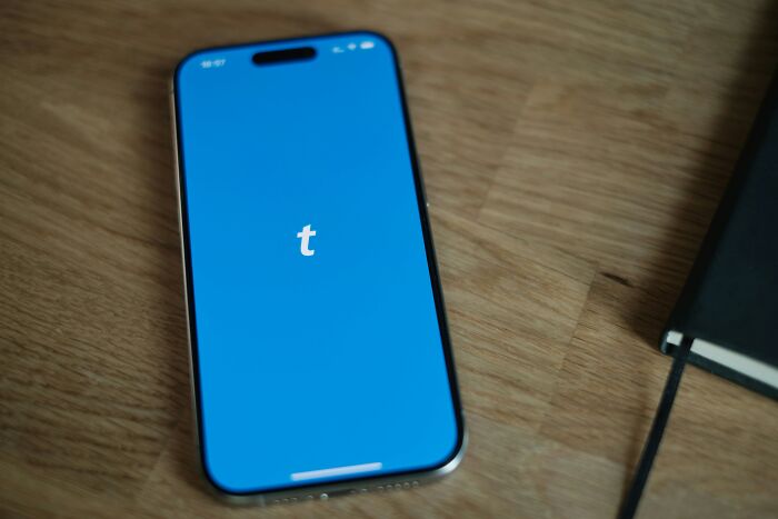 Smartphone on wooden table showing Tumblr app, illustrating overhyped products people say everyone should stop buying.