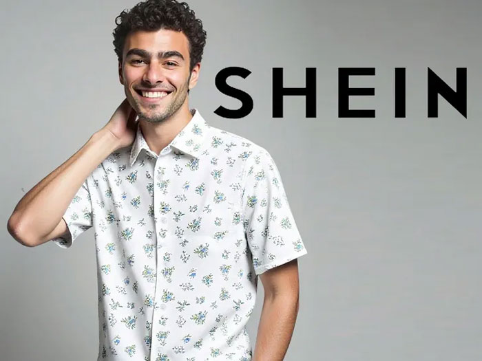 Luigi Mangione smiling in a floral shirt posing in front of a gray background with the Shein logo.