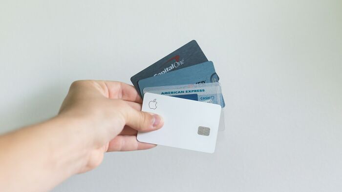 Hand holding multiple credit cards, illustrating money-saving tips and strategies for saving thousands of dollars.