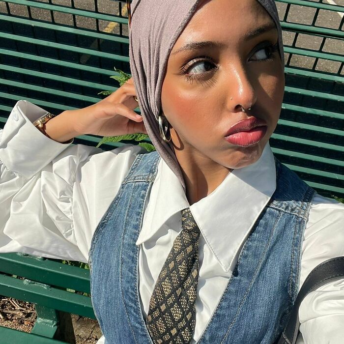 Young woman posing outdoors wearing a hijab and denim vest, related to a viral moment in a gay running club signup. Young woman posing outdoors wearing a hijab and denim vest, related to a viral moment in a gay running club signup.