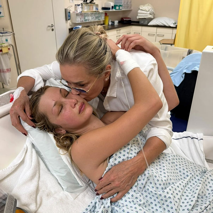Yolanda Hadid comforting daughter Bella in a hospital bed, expressing emotional support during her struggle with pain.