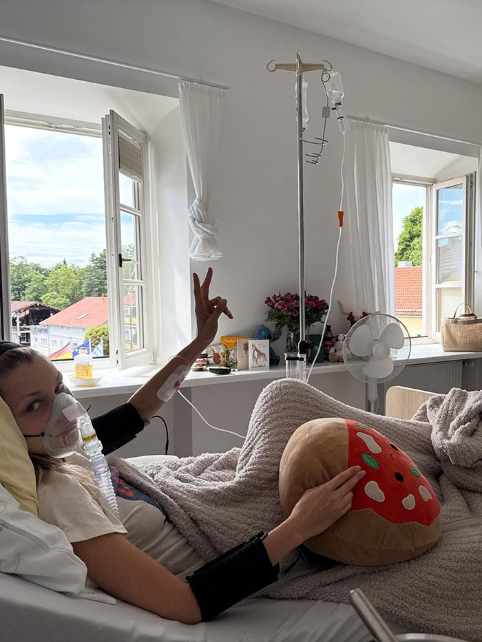 Bella Hadid in hospital bed with oxygen mask and IV drip, showing signs of years of invisible suffering.