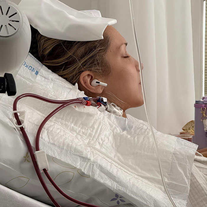 Bella Hadid lying in hospital bed with medical tubes connected, highlighting her struggle with darkness and pain.