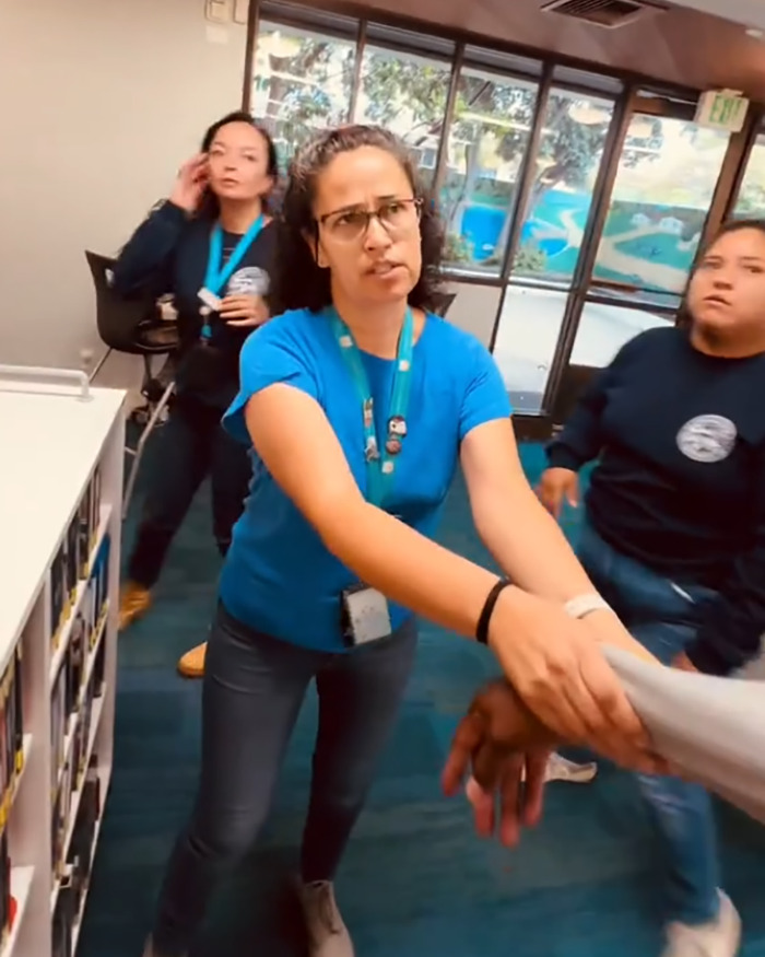 Library staff intervene as a black man confronts a white man over racial slur during a tense viral video incident.