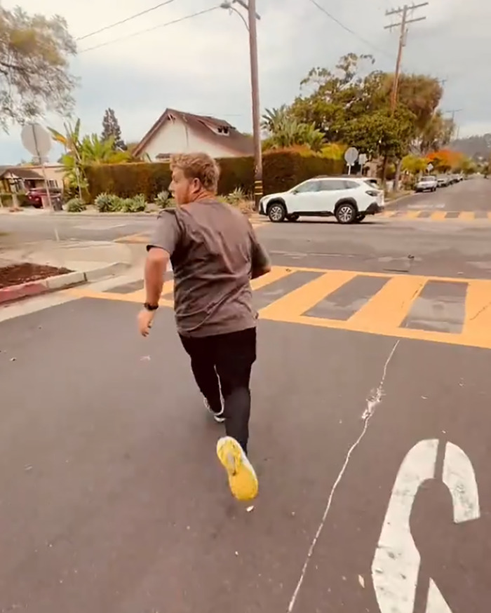 White man running away on street after confrontation with black man outside library in viral video about racial slur incident.