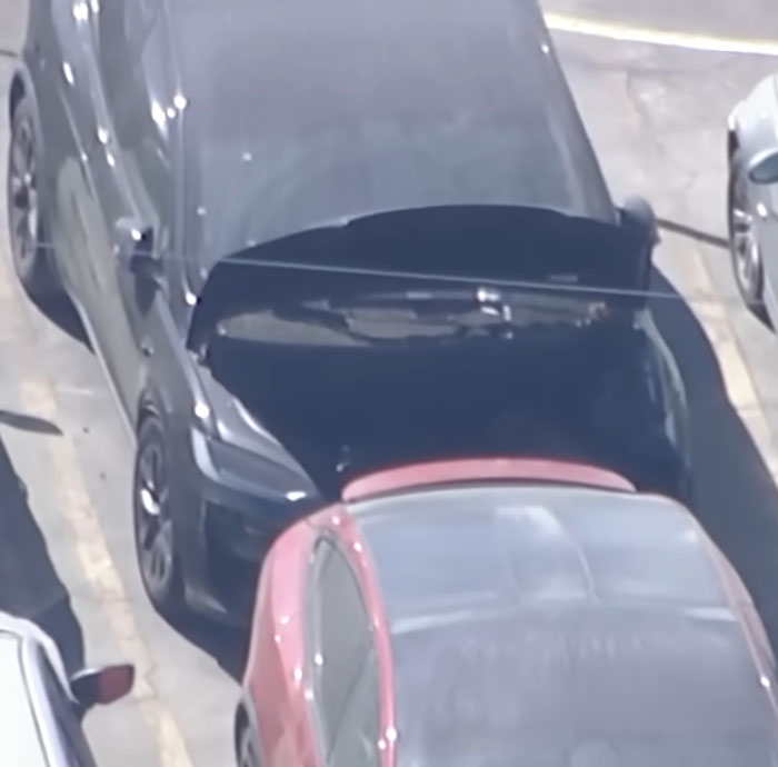 Black and red cars parked in a lot during an investigation linking singer to body of girl missing over a year