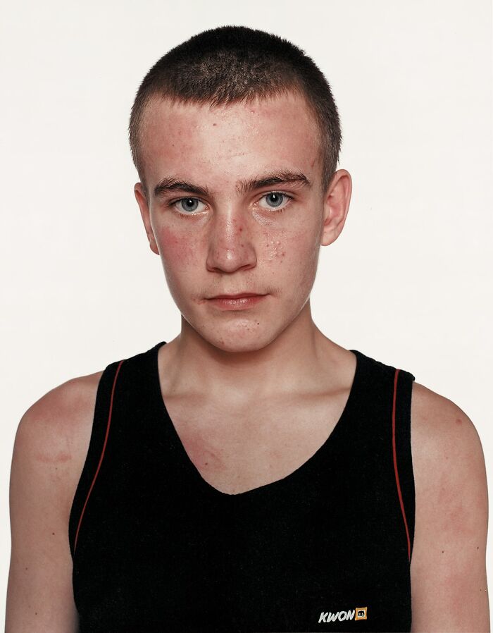 Young boxer with a serious expression wearing a black sports tank top in a powerful portrait before his first match