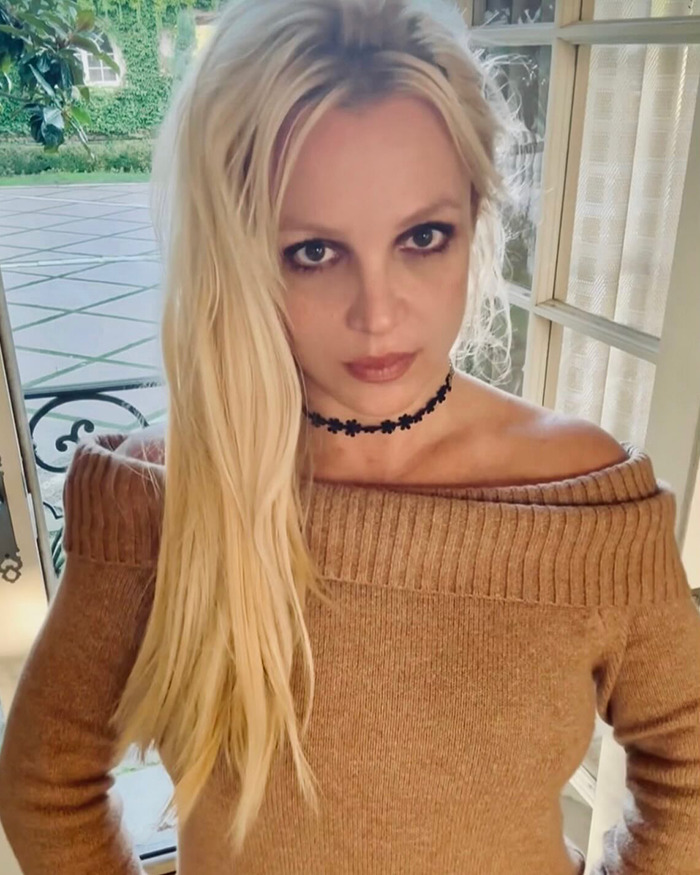 Britney Spears posing indoors wearing a brown off-shoulder sweater and black choker, her inner circle concerned over behavior changes. Britney Spears posing indoors wearing a brown off-shoulder sweater and black choker, her inner circle concerned over behavior changes.