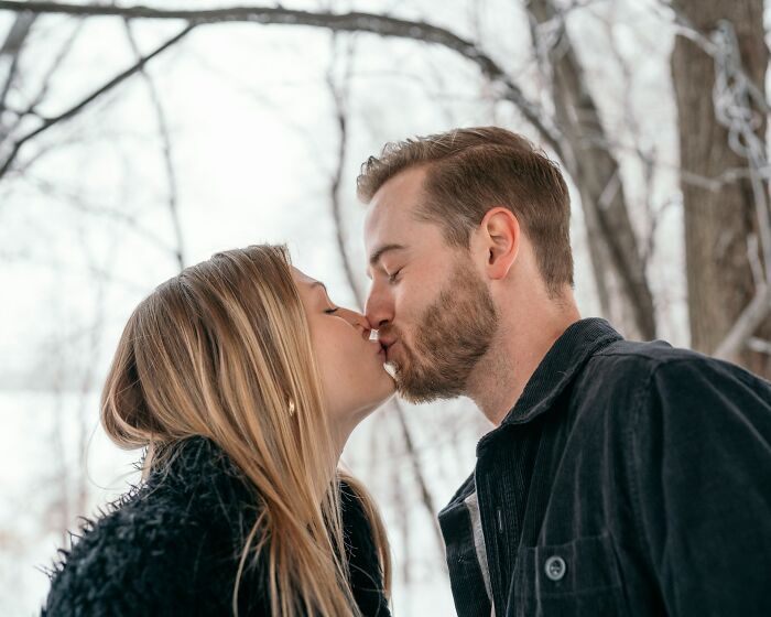 Couple sharing a tender kiss outdoors in winter, illustrating signs a relationship isn’t going to last.