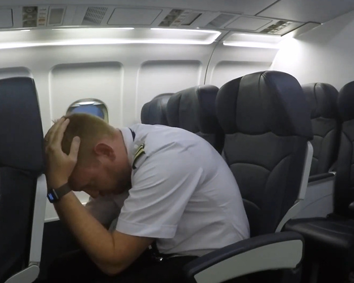 Pilot in a plane crash simulation demonstrating emergency actions passengers should avoid during an in-flight crisis situation. Pilot in a plane crash simulation demonstrating emergency actions passengers should avoid during an in-flight crisis situation.