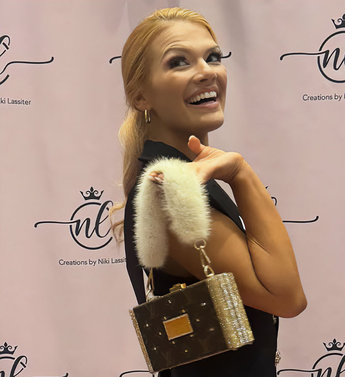 Miss America smiling and posing with stylish handbag, addressing backlash over her look after winning the pageant.