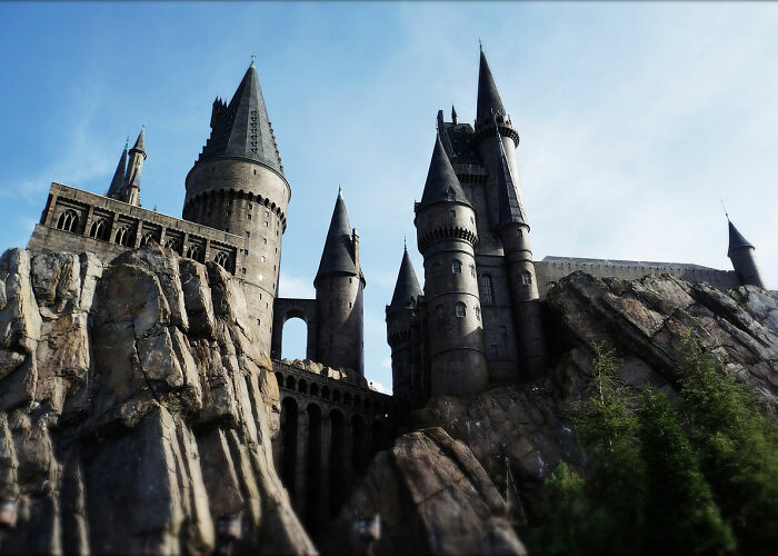 Ancient castle towering over rocky cliffs under a blue sky, evoking memories of wildest rules people grew up with.