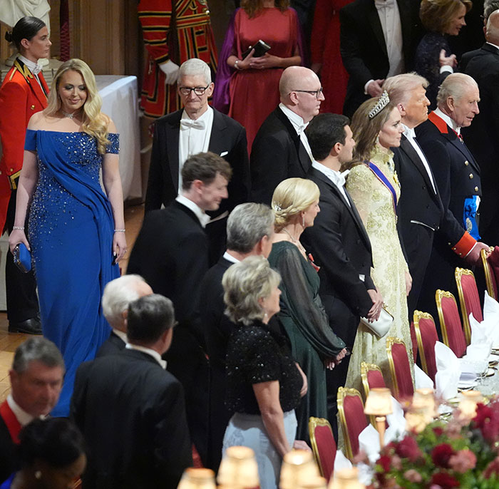 Kate Middleton standing beside a Trump relative at a formal state banquet with guests in elegant attire. Kate Middleton standing beside a Trump relative at a formal state banquet with guests in elegant attire.