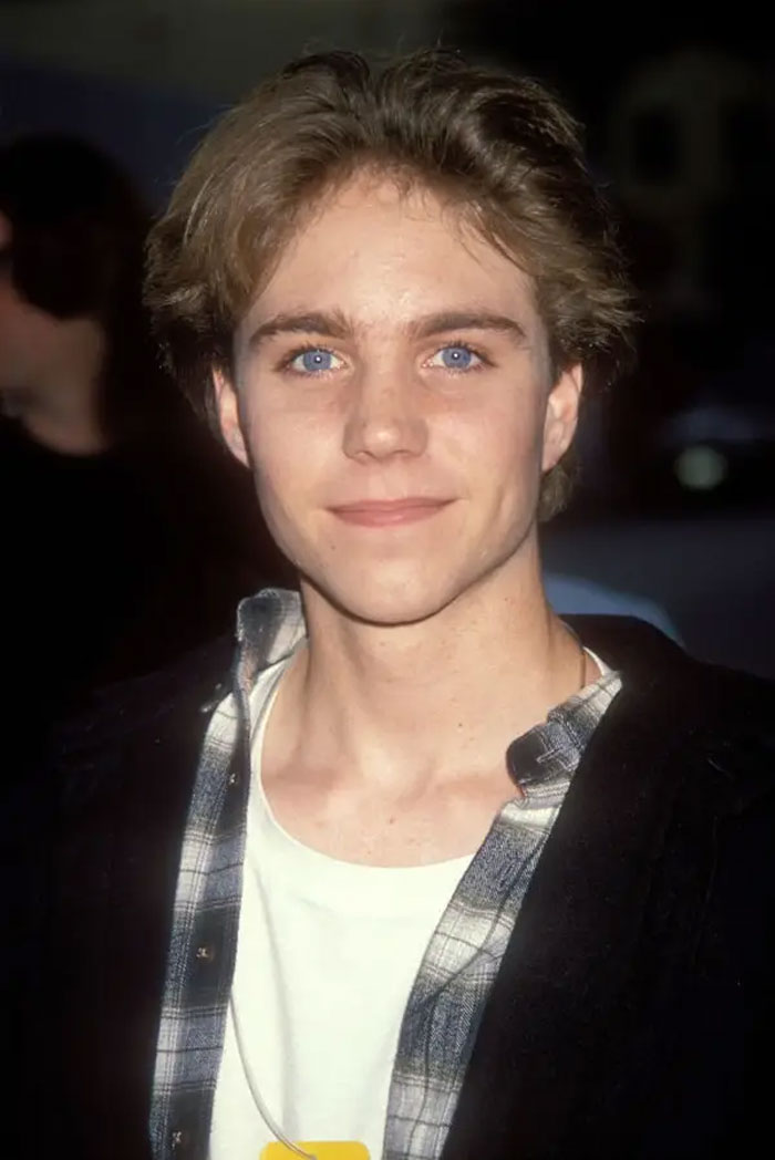 Young male child star with blue eyes and light brown hair at a public event, representing child stars who passed away young.