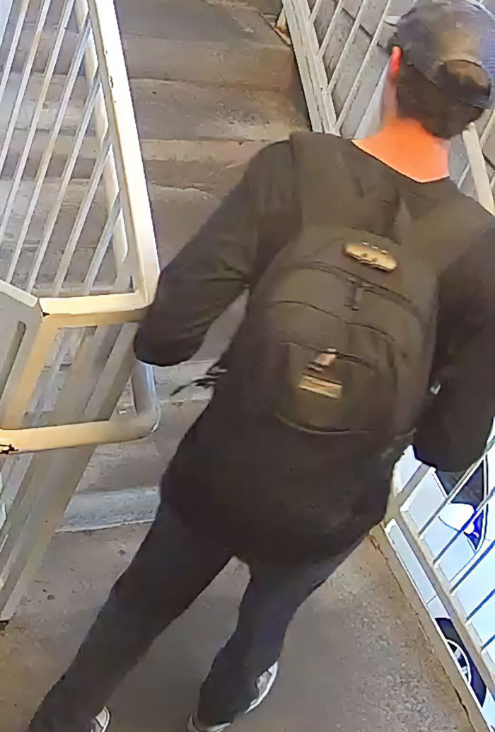 Main suspect in Charlie Kirk fatal attack seen escaping in CCTV footage, wearing black clothing and a backpack on outdoor stairs.