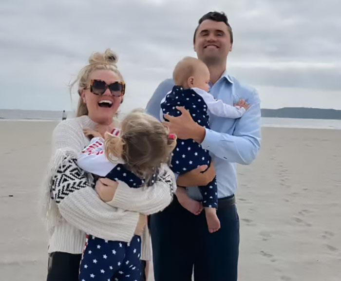 Iryna Zarutska with family at the beach, holding children, enjoying a cloudy day near the ocean.