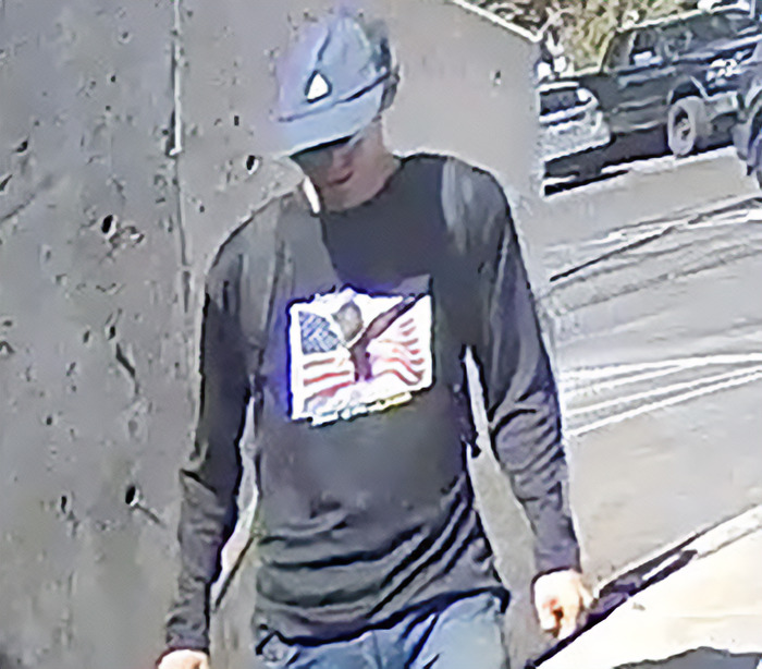 Man wearing a helmet and an American flag shirt walking outside, related to Charlie Kirk suspect Tyler Robinson court appearance.