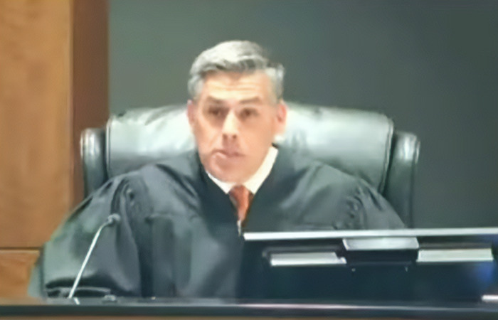 Judge wearing black robe presiding over a court session involving suspect Tyler Robinson in the Charlie Kirk case.