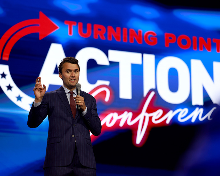 Man in a suit speaking at Turning Point USA event, relating to Erika Kirk appointed CEO of Turning Point USA.