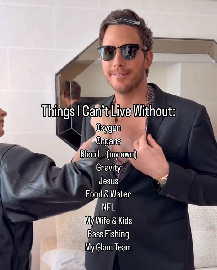 Chris Pratt smiling in sunglasses and suit while being helped with styling, linked to viral clip of his unusual praying style.