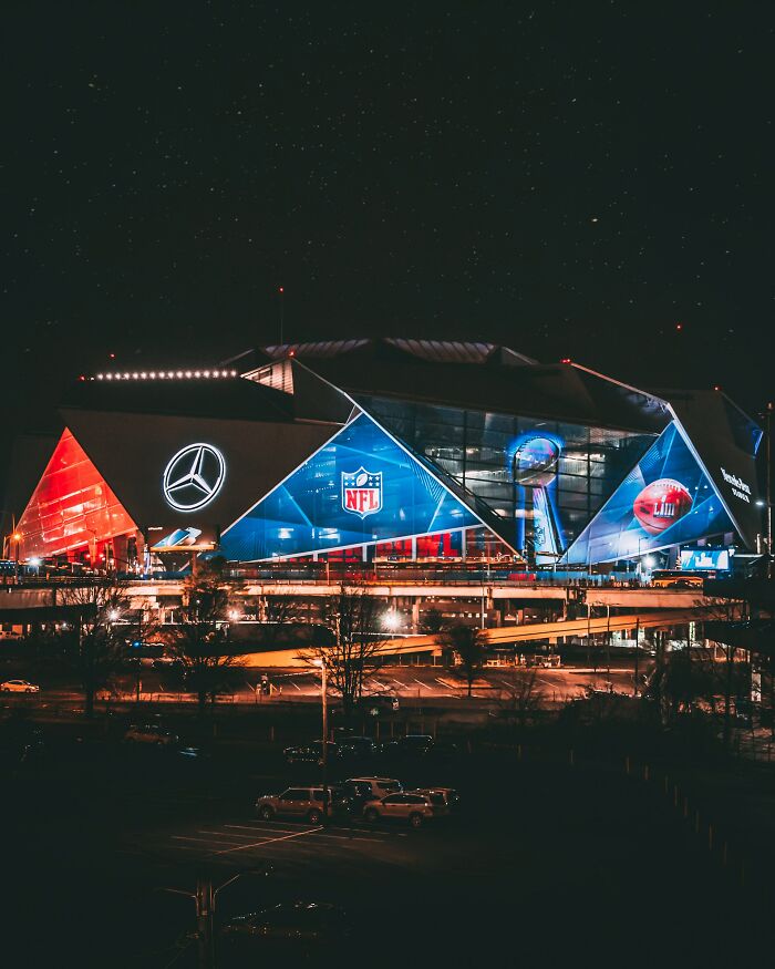 NFL stadium lit up at night under a starry sky, illustrating things women are not allowed to do that men can do freely.