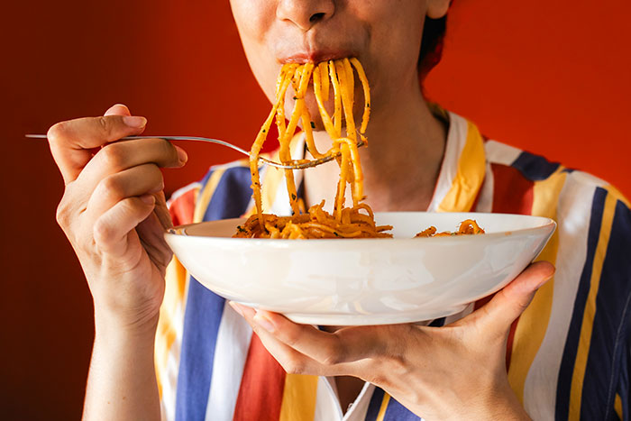 Person eating noodles from a white bowl, illustrating one of the most ridiculous cures offered to chronically ill people.