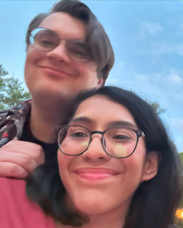 Conjoined twin and husband smiling outdoors, sharing a moment while addressing intimacy and marriage questions.