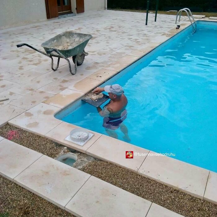 Man doing construction work while standing inside a swimming pool, illustrating poor design and construction ideas.