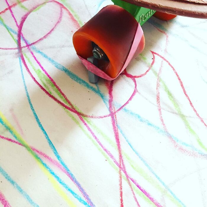 Close-up of a creative kid’s drawing machine wheel leaving colorful crayon lines, showcasing new inventions by kids.