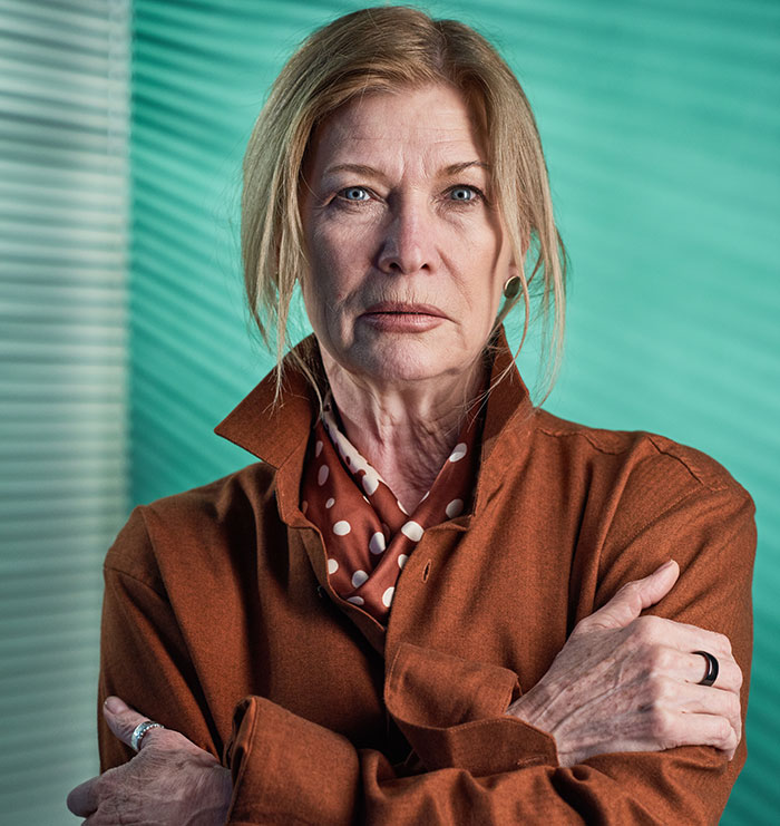 Serious older woman standing with arms crossed, representing crazy things heard from MILs that need to calm down.