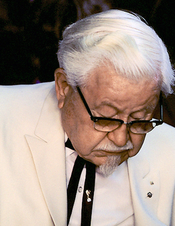 Elderly man with white hair and glasses in a white suit, reflecting on history anecdotes and lessons from the past.