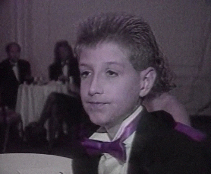 Young boy in vintage attire at a formal event, illustrating a history anecdote from the past.
