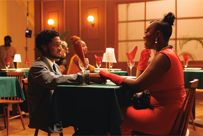 Couple holding hands at a dimly lit restaurant table, experiencing a creepy moment they can't explain.