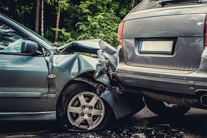 Two damaged cars after a collision in a forested area, illustrating creepy things people can’t explain from accidents.