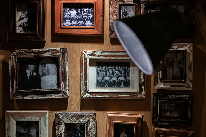 Vintage black and white photos in rustic frames under a spotlight, evoking creepy experiences people can’t explain.