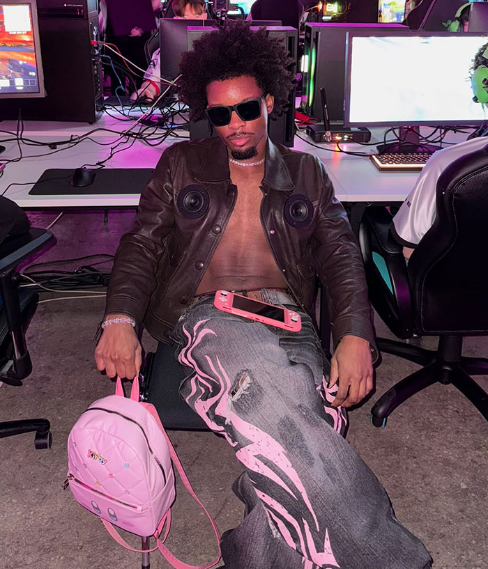 Singer wearing sunglasses and leather jacket sitting in gaming chair, connected to wild findings in missing girl case.