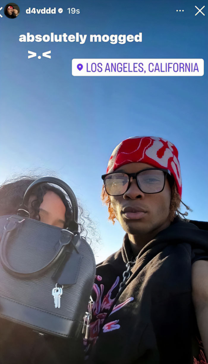 Young singer wearing red bandana and glasses taking selfie outdoors in Los Angeles linked to body of missing girl case.