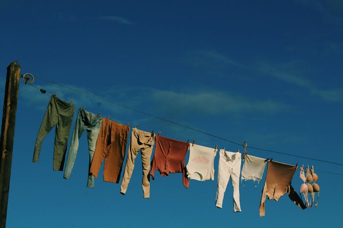 Worn and damaged clothes hanging on a line, illustrating companies that sabotage their own products in consumer examples.