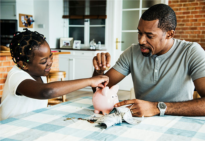 Father and daughter saving money together with a piggy bank, discussing fairness about buying expensive items.