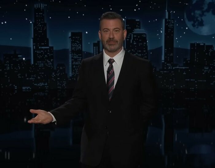 Jimmy Kimmel on set at night, wearing a suit and tie, addressing staff mutiny threats before his return. Jimmy Kimmel on set at night, wearing a suit and tie, addressing staff mutiny threats before his return.